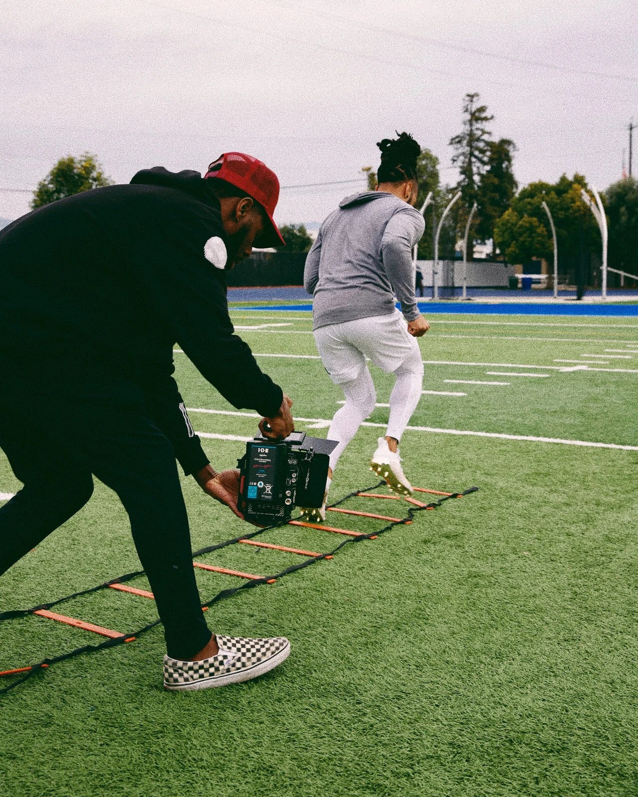 Aaron filming an athlete on a football field