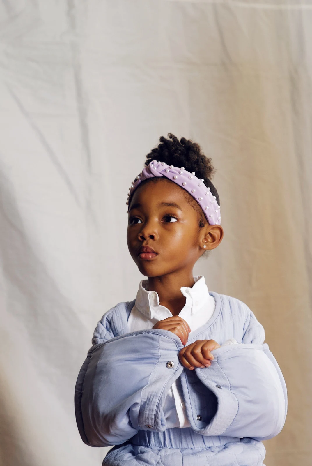 A child in a white shirt and headband